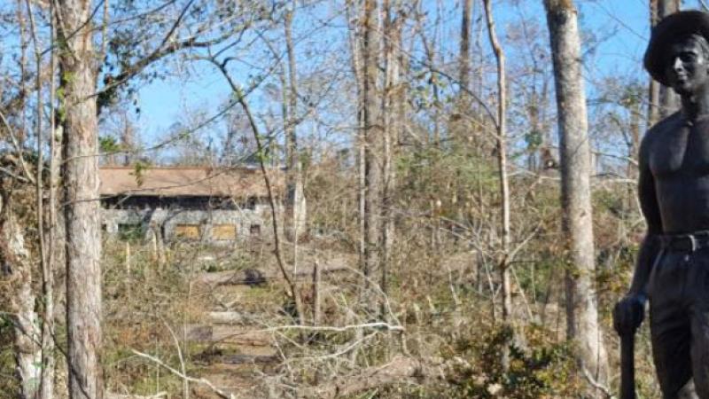 A view of the Civilian Conservation Crops Statue among the destruction.